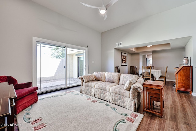 living area with baseboards, plenty of natural light, visible vents, and wood finished floors