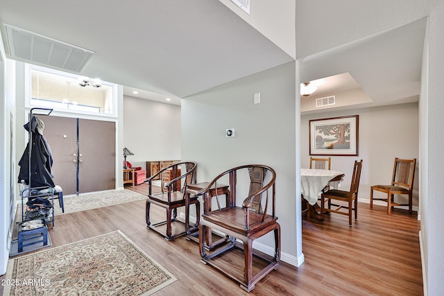 sitting room with light wood-style floors, baseboards, and visible vents