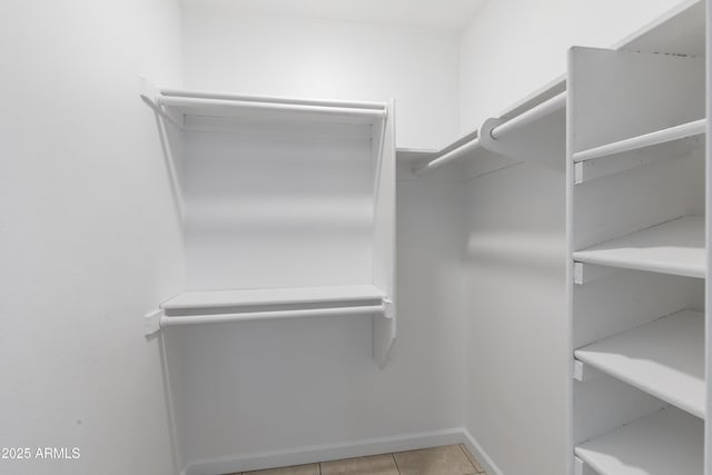 walk in closet with light tile patterned floors