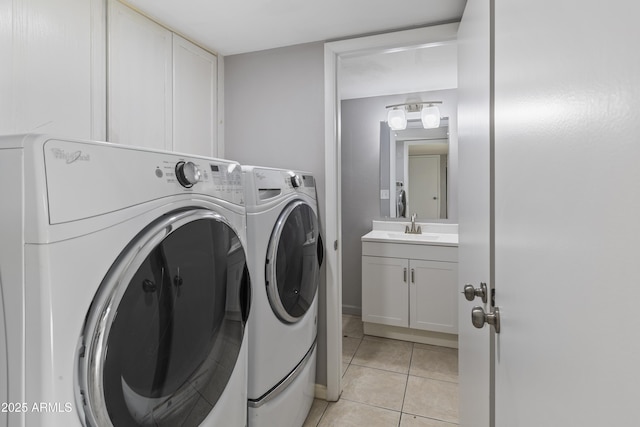 clothes washing area featuring cabinets, washer and clothes dryer, sink, and light tile patterned floors