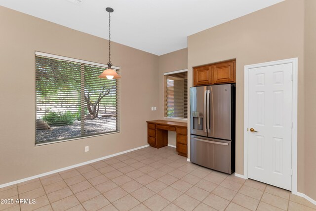 42122 N Anthem Springs Rd, Anthem, AZ 85086 - kitchen featuring stainless steel fridge, brown cabinetry, light tile patterned floors, and decorative light fixtures