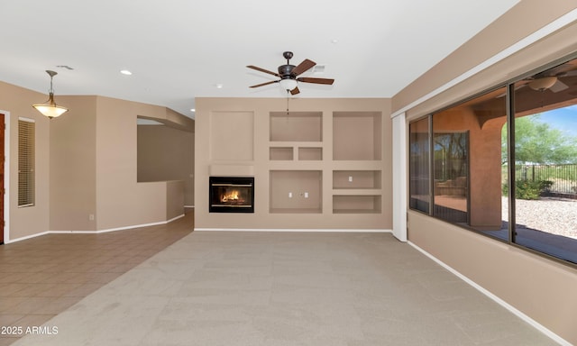 42122 N Anthem Springs Rd, Anthem, AZ 85086 - unfurnished living room featuring a ceiling fan, recessed lighting, a glass covered fireplace, and built in features