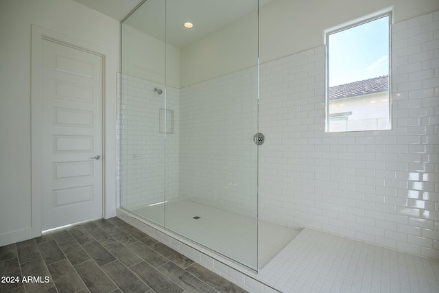 full bath with a walk in shower and wood finish floors