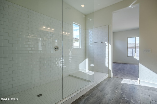 full bathroom with baseboards, tiled shower, and wood finish floors