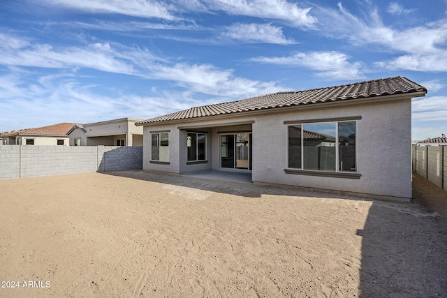 back of property featuring a patio area, a fenced backyard, a tiled roof, and stucco siding