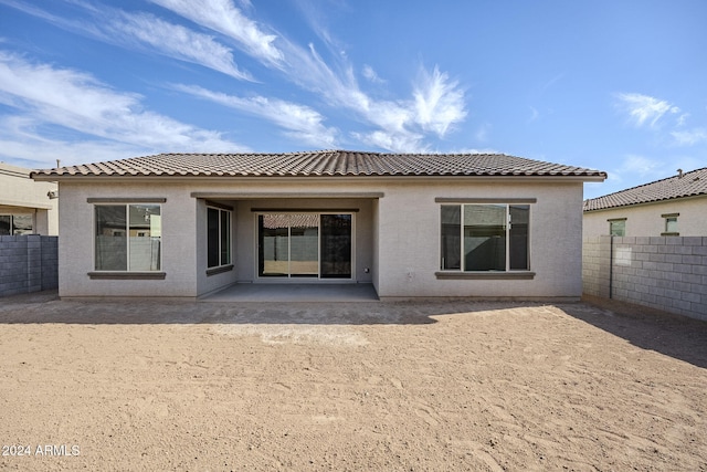 back of property featuring stucco siding, a fenced backyard, a tile roof, and a patio