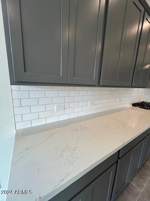 kitchen with decorative backsplash and light stone countertops