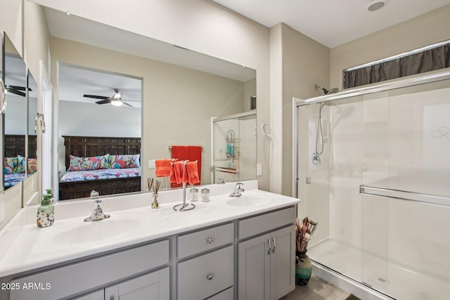 5724 N 108th Ave, Phoenix, AZ 85037 - bathroom featuring ensuite bathroom, a stall shower, double vanity, ceiling fan, and wood finished floors