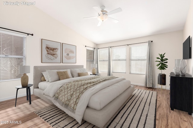 bedroom with vaulted ceiling, light wood finished floors, a ceiling fan, and baseboards