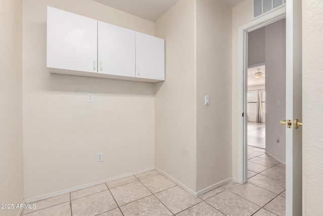 clothes washing area featuring a ceiling fan, visible vents, baseboards, and light tile patterned floors