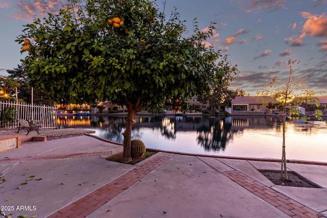 exterior space with a patio area, a water view, and fence