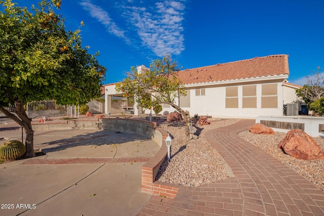 single story home with a patio, central AC, a tiled roof, and stucco siding