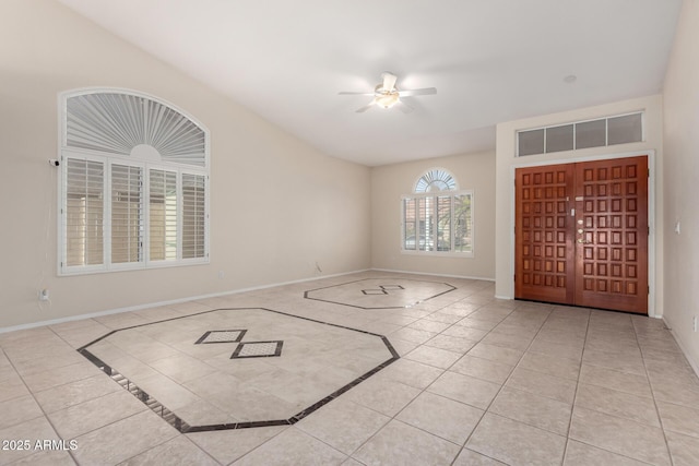 entryway with tile patterned flooring, a ceiling fan, and baseboards