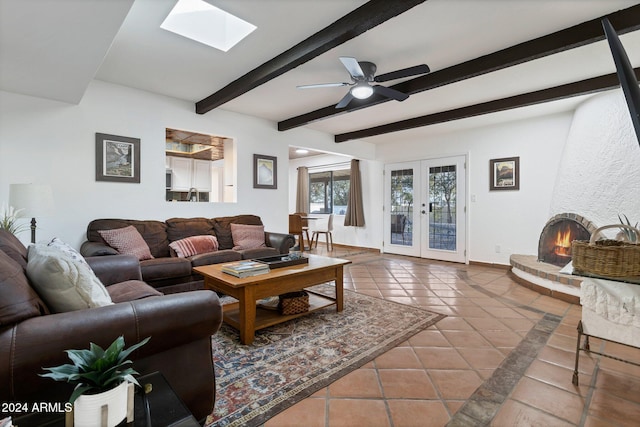 living room with beam ceiling, a skylight, ceiling fan, french doors, and tile patterned flooring