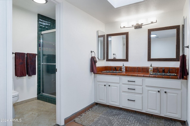 bathroom featuring tile patterned floors, vanity, toilet, and walk in shower