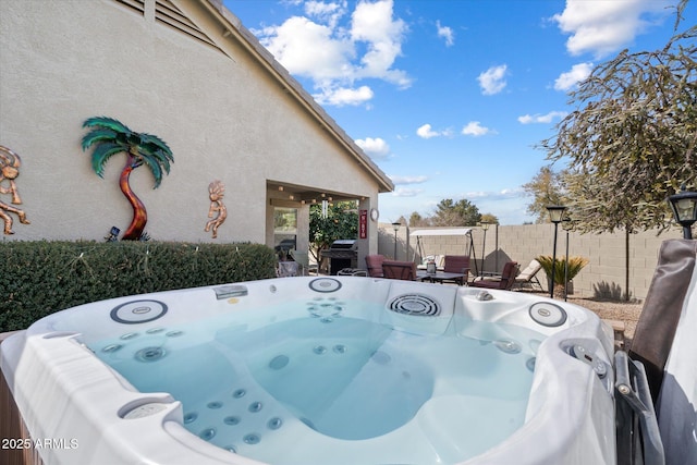 exterior space with grilling area and a hot tub