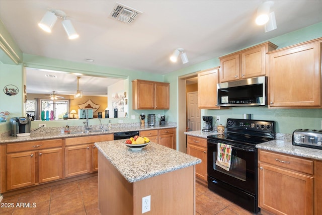 kitchen with a kitchen island, black appliances, hanging light fixtures, light tile patterned floors, and kitchen peninsula