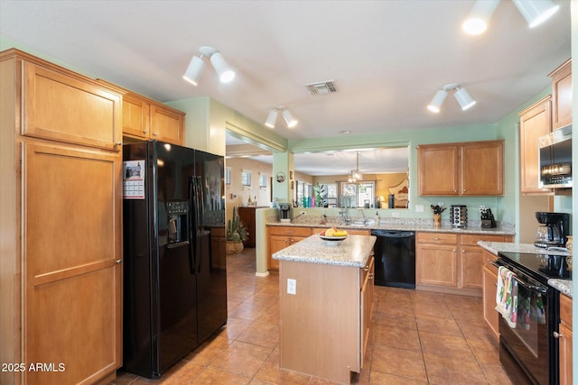 kitchen with light tile patterned flooring, a center island, kitchen peninsula, and black appliances