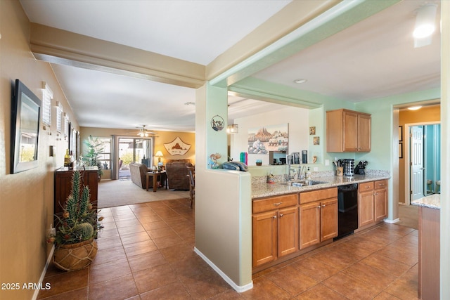 kitchen with light tile patterned flooring, sink, dishwasher, ceiling fan, and light stone countertops