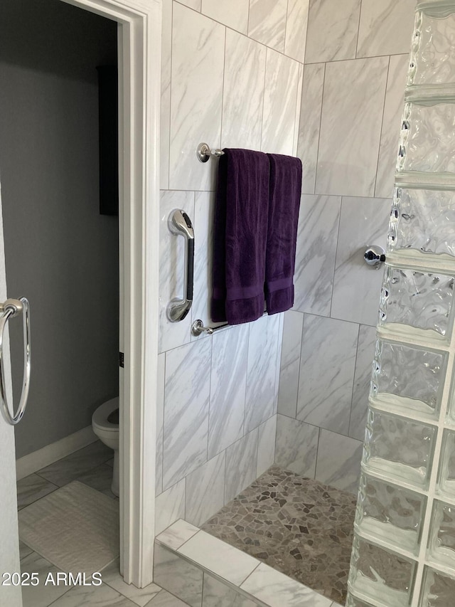 bathroom featuring toilet and tiled shower