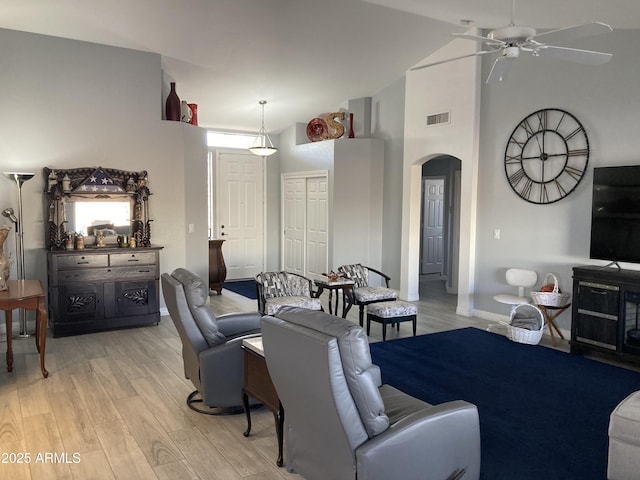 living room featuring ceiling fan, light wood-type flooring, and high vaulted ceiling