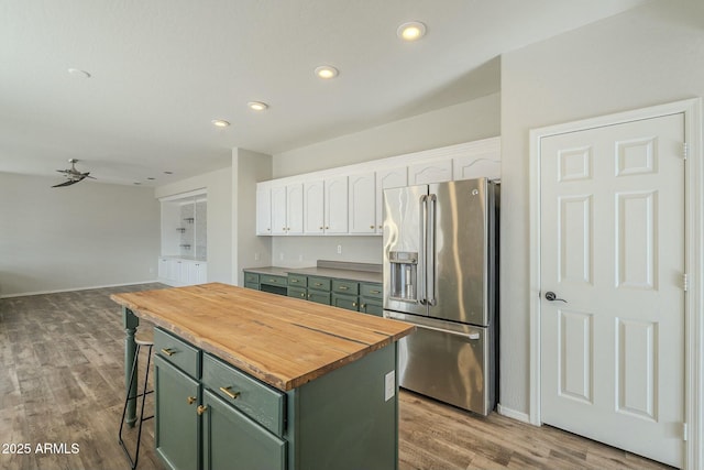 kitchen with wood counters, white cabinets, stainless steel fridge with ice dispenser, and green cabinetry