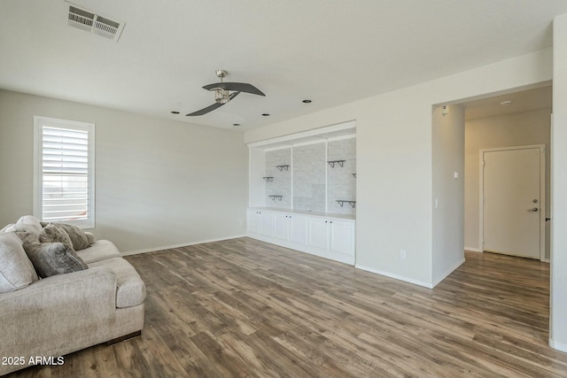 living area featuring a ceiling fan, wood finished floors, visible vents, and baseboards