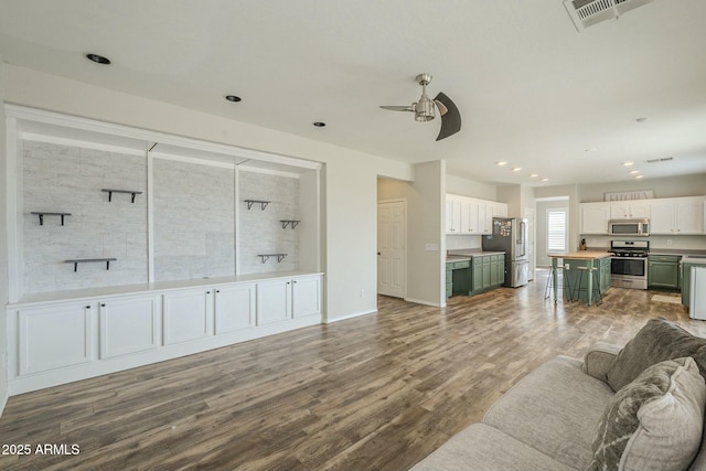 living area with visible vents, wood finished floors, recessed lighting, baseboards, and ceiling fan