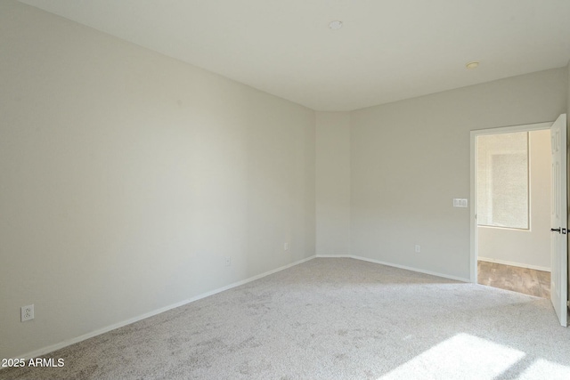 carpeted empty room featuring baseboards