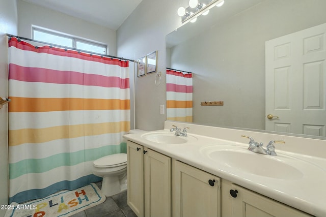 full bath with a sink, toilet, double vanity, and tile patterned flooring