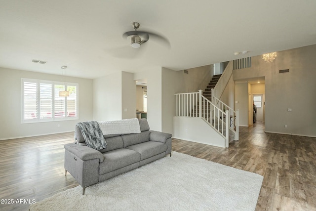 living room with visible vents, wood finished floors, and stairs