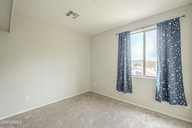 carpeted spare room with visible vents and baseboards