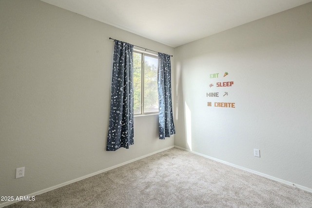 unfurnished room featuring carpet and baseboards