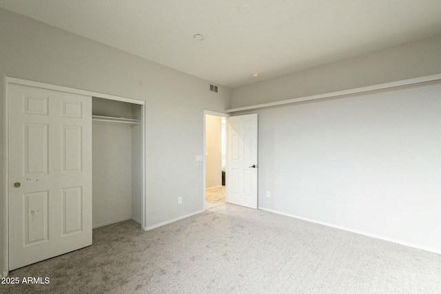 unfurnished bedroom featuring visible vents, carpet floors, baseboards, and a closet