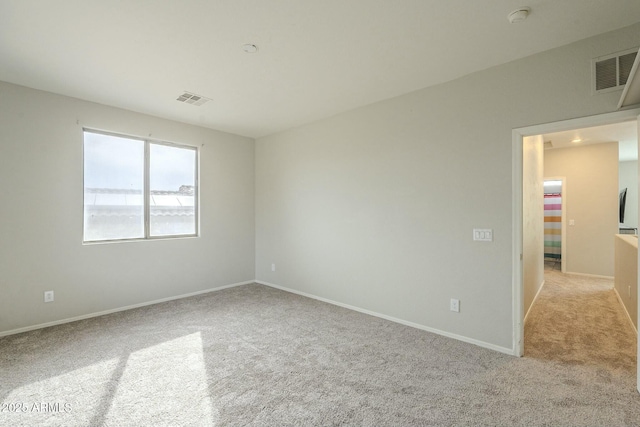 carpeted spare room with baseboards and visible vents