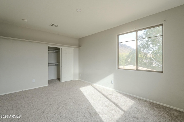 unfurnished bedroom featuring a closet, baseboards, visible vents, and carpet floors