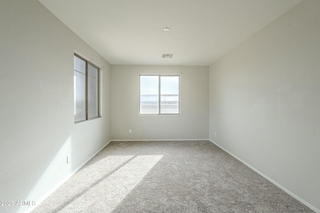 carpeted empty room featuring visible vents and baseboards