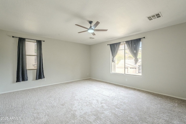 carpeted empty room featuring visible vents, baseboards, and a ceiling fan