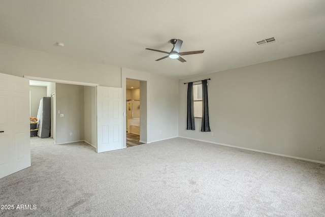 unfurnished bedroom with visible vents, a ceiling fan, connected bathroom, carpet, and baseboards