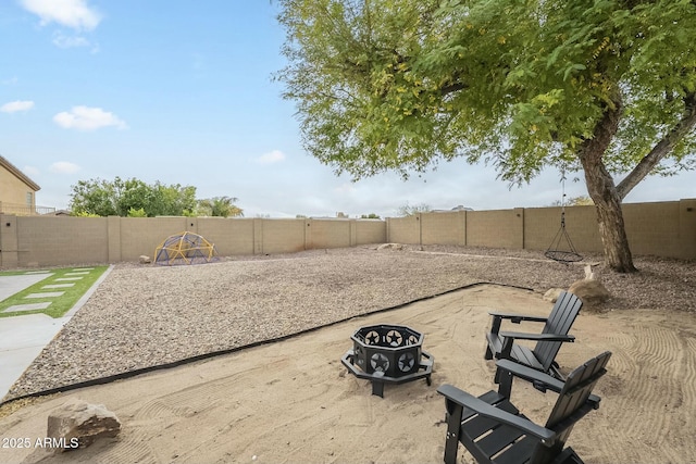 view of yard featuring a patio area, a fenced backyard, and an outdoor fire pit