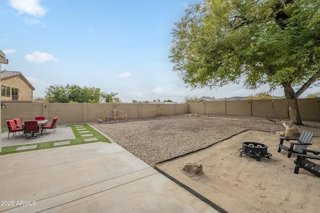 view of yard featuring a fenced backyard, an outdoor fire pit, and a patio