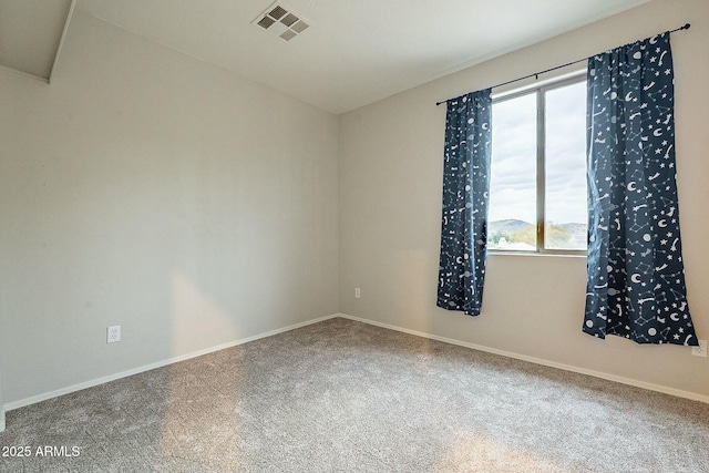 carpeted spare room featuring baseboards and visible vents