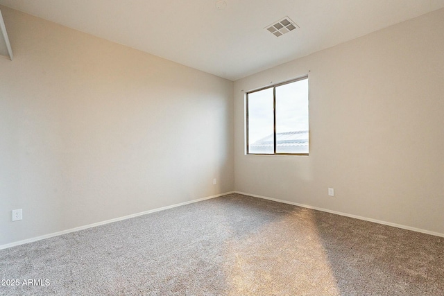 empty room with carpet flooring, baseboards, and visible vents