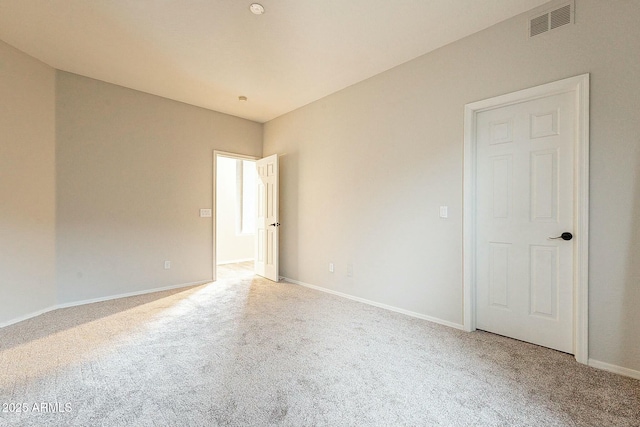 carpeted spare room featuring baseboards and visible vents