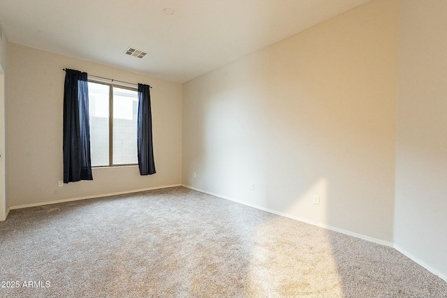 carpeted spare room with baseboards and visible vents