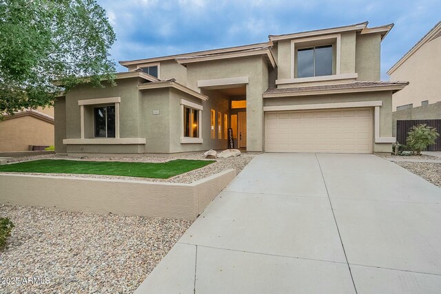 prairie-style home featuring stucco siding, concrete driveway, and an attached garage