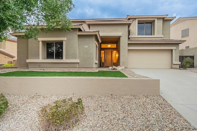 prairie-style house with stucco siding, a garage, and driveway