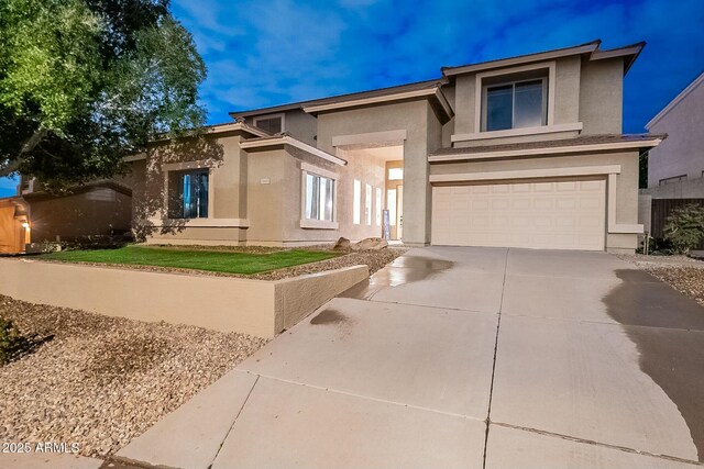 view of front of property with stucco siding, concrete driveway, and an attached garage