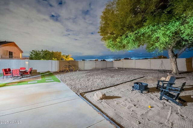 view of yard with a patio, a fenced backyard, and a fire pit