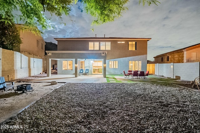 back of property with a patio area, stucco siding, and a fenced backyard